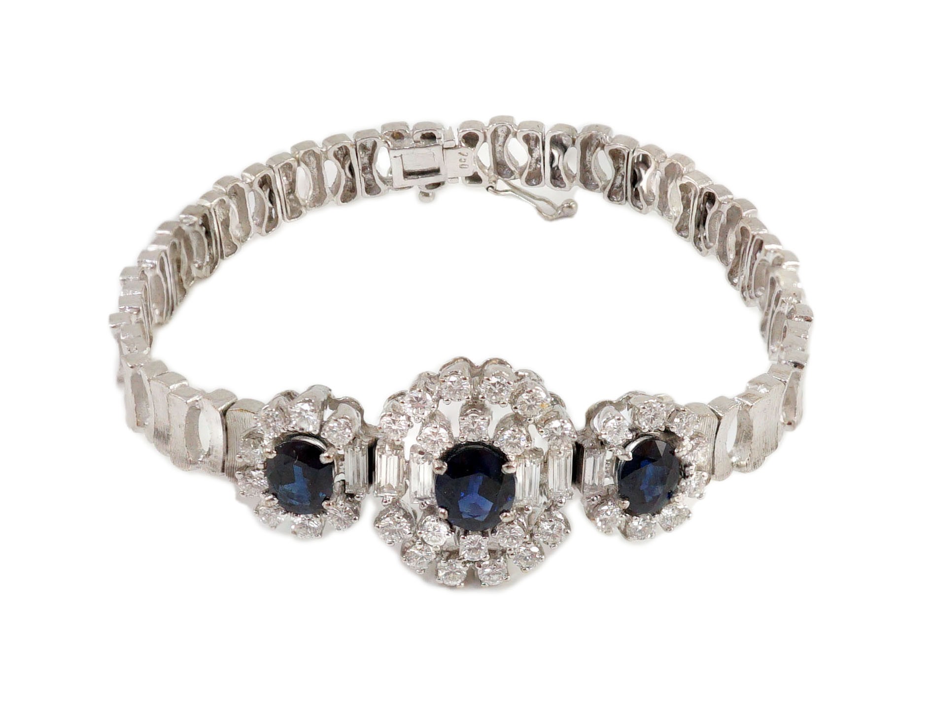 A mid to late 20th century textured 18k white gold, sapphire, round and baguette cut diamond set triple oval cluster bracelet